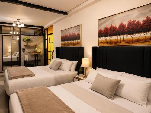 two beds in a bedroom with a painting on the wall at Ica Adventures II in Ica