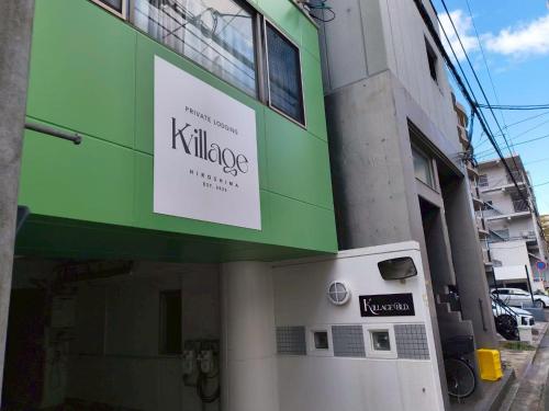 a building with a sign on the side of it at Kvillage BLDG 無料駐車場付き 原爆ドームまで徒歩15分 大人数でもOK in Hiroshima