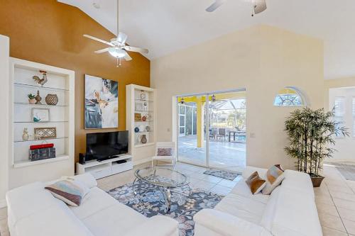 a living room with a white couch and a tv at Waterfront Hideaway in Cape Coral