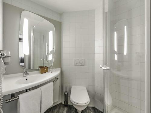 a bathroom with a toilet and a sink and a shower at ibis Innsbruck in Innsbruck