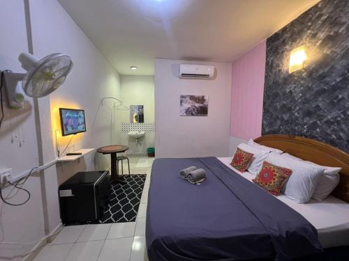 a bedroom with a bed with a hat on it at Little Chenang Cottage Motel Langkawi in Pantai Cenang