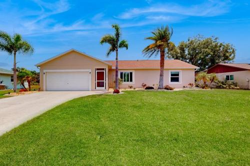 a house with palm trees in a yard at No Regrets in Englewood