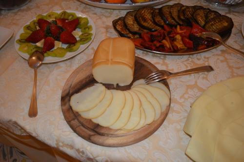 a table topped with cheese and a plate of food at Hotel L'Antico Convitto in Amalfi