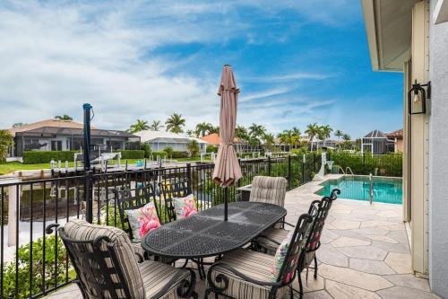 a patio with a table and chairs and an umbrella at Marco Island Majesty in Marco Island