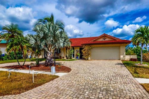 a house with a palm tree in front of it at Marco Island Manor in Marco Island