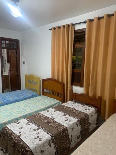 a bedroom with two beds and a window at Quartos petrolina 02 in Petrolina