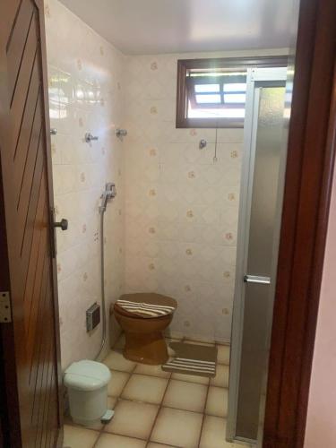 a small bathroom with a toilet and a window at Quartos petrolina 02 in Petrolina