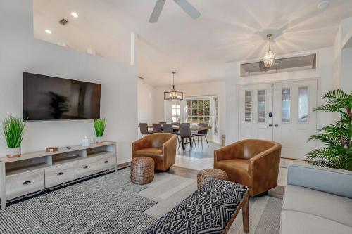 a living room with a tv and a couch and a table at Hook, Line, and Sunsets in Port Charlotte