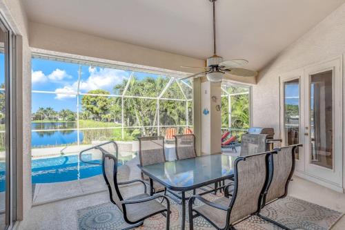 a dining room with a table and chairs and a large window at Sable Retreat in Cape Coral