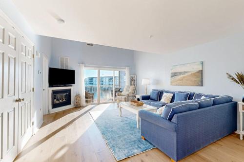 a living room with a blue couch and a fireplace at Bethany Bay --- 37182 Harbor Dr #2606 in Ocean View