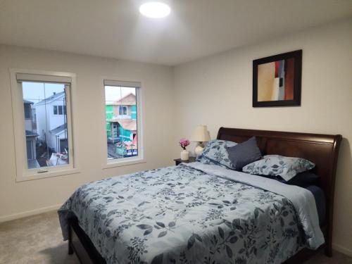a bedroom with a bed and two windows at Edmonton 3BR House in Edmonton
