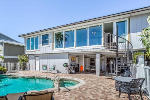 a home with a swimming pool and a house at Madagascar Palm in Marco Island