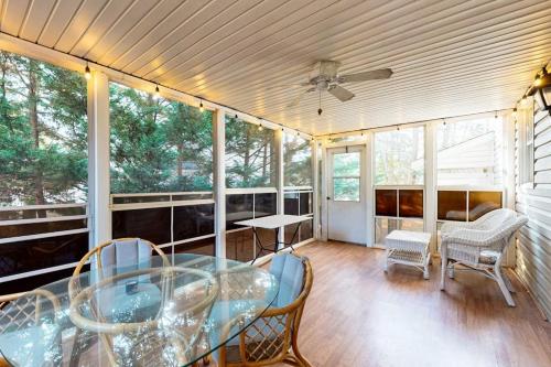 a screened in porch with a glass table and chairs at Salt Pond --- 669 Bethany Loop in Bethany Beach