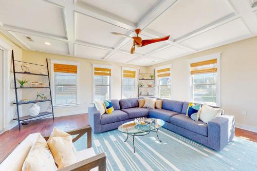 a living room with a blue couch and a ceiling fan at Watermark North --- 38918 Silver Sands Dr in Bethany Beach