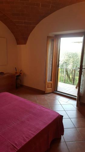 a bedroom with a bed and a sliding glass door at Orto degli Ulivi in Sinalunga