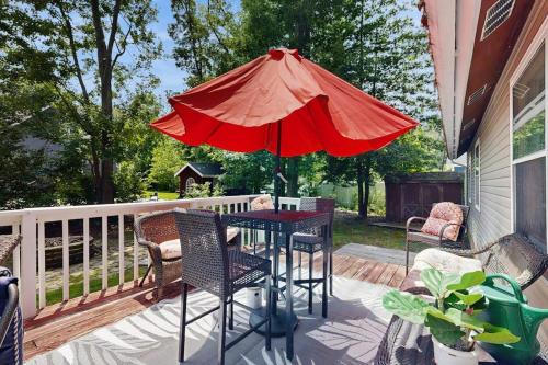 a table with a red umbrella on a deck at Neck Village in Ocean View