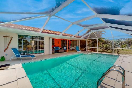 a swimming pool with a pergola and a house at Seaside Serenity in Punta Gorda