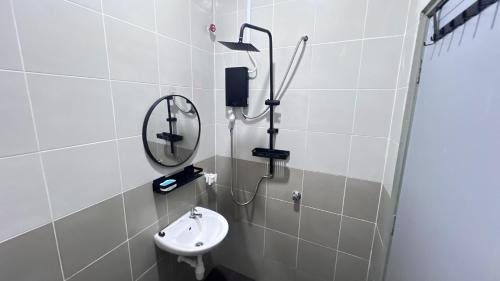 a bathroom with a sink and a mirror at Razumi's Homestay 3 in Arau