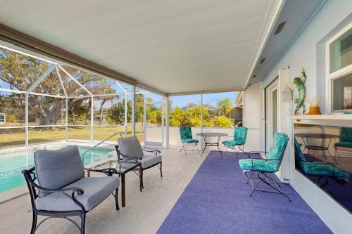 a room with chairs and a table and a pool at Lil Blue in Punta Gorda