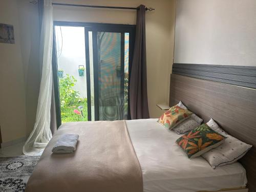 a bedroom with a large bed with a window at Résidence MBK in Ziguinchor