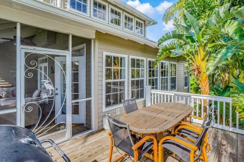 a porch with a wooden table and chairs on a deck at Bocilla Breeze in Bokeelia