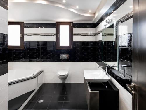 a black and white bathroom with a toilet and a sink at Rhodian Villa in Kremasti