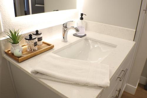 a white bathroom sink with a white towel on it at Dropper Post Bike Retreat Near OZ Trails & AMP in Rogers