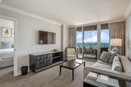 a living room with a couch and a bed and a television at Marco Beach Ocean Resort 807 in Marco Island