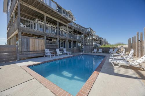 a swimming pool with lounge chairs and a building at 7674 - The Sweet Escape in Avon