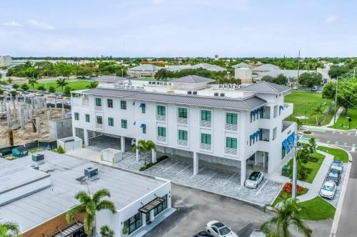 an aerial view of a white building with a parking lot at SoCe Flats 209 in Naples