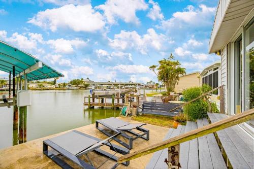a house with a dock with two chairs and a table at Sunset Escape in Marco Island