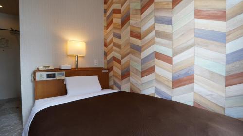 a bedroom with a bed with a colorful wall at Hotel New Gaea Itoshima in Itoshima