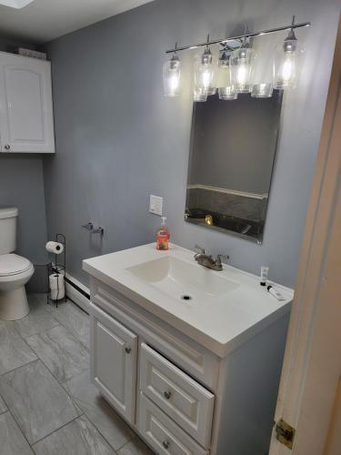 a bathroom with a white sink and a mirror at Single Level Spacious Home - A JBMB Property in Middletown