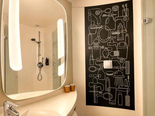 a bathroom with a black and white wall at Hotel ibis Dijon Centre Clemenceau in Dijon