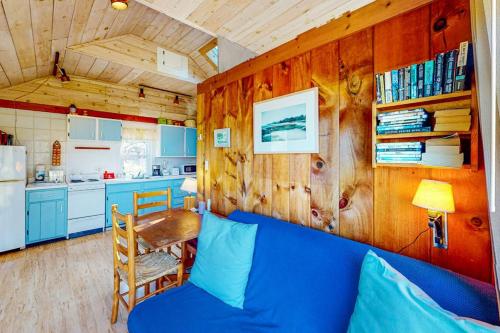a living room with a blue couch and a kitchen at North Truro Bayside Gem in Truro