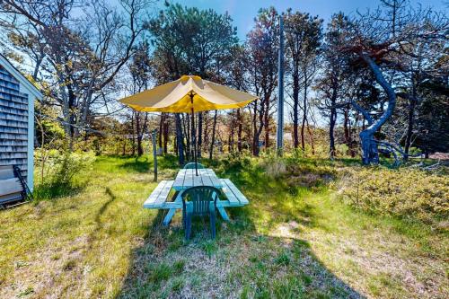 a picnic table with an umbrella in the grass at North Truro Bayside Gem in Truro