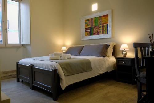 1 dormitorio con 1 cama grande y 2 lámparas. en EOS Room and Breakfast, en Iglesias