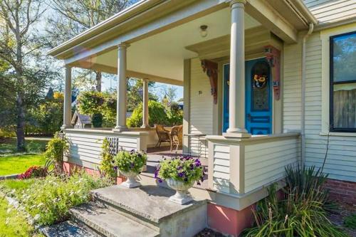a front porch of a house with two vases of flowers at Old Mansard in West Dennis
