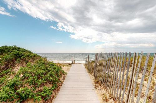 a wooden path to the beach with a fence at National Seashore Studio in Truro
