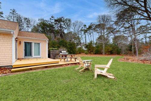 a backyard with a picnic table and two benches at Herring Brook in Eastham