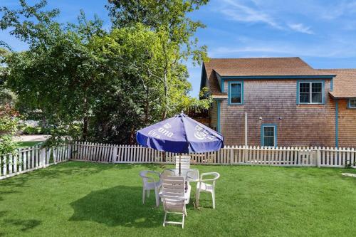 a table and chairs and an umbrella in a yard at TumbleINN in Oak Bluffs