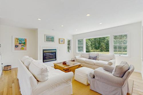 a living room with white furniture and a fireplace at Family Getaway in Oak Bluffs