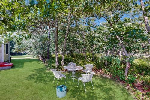 a table and chairs in a yard with trees at Family Getaway in Oak Bluffs
