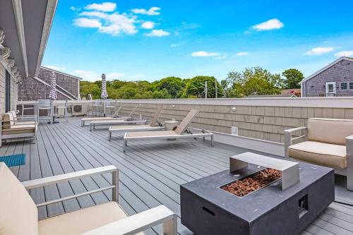a patio with chairs and a fire pit on a roof at Fun in the Sun in Provincetown