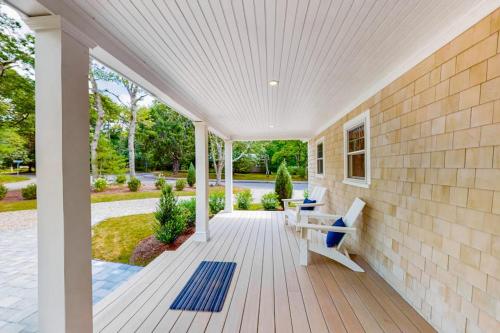 a porch of a house with a bench on it at The Cape House in Cotuit