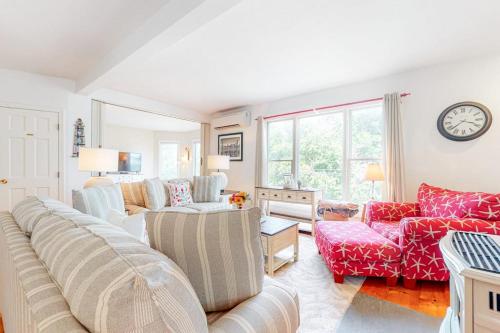 a living room with a couch and chairs and a clock at Main Street Upper in Vineyard Haven