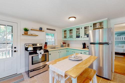 a kitchen with blue cabinets and a stainless steel refrigerator at Downtown Seaside Serenity Retreat in Hyannis