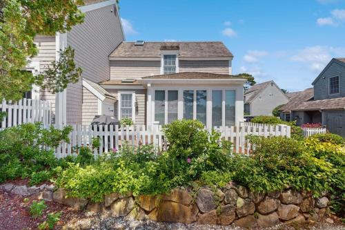 a white fence in front of a house at Shoreline Escape in Mashpee