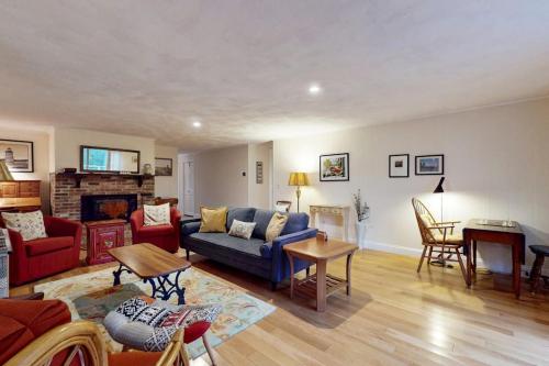a living room with a blue couch and a fireplace at Tall Pines in Wellfleet