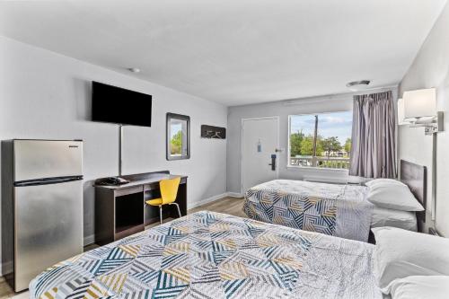 a hotel room with two beds and a desk at Studio 6 Wilmington, NC in Wilmington